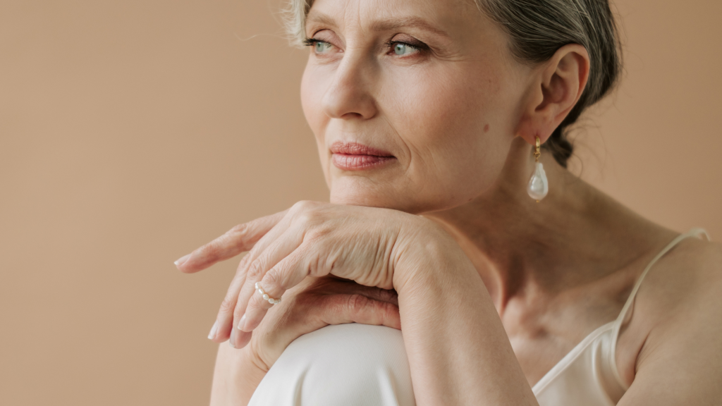 donna over 50 con la mano sotto il mento che guarda fisso davanti a sè
